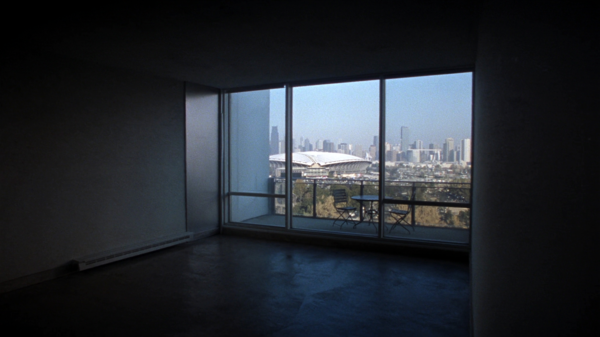Empty brand-new condo unit with floor-to-ceiling windows overlooking the city