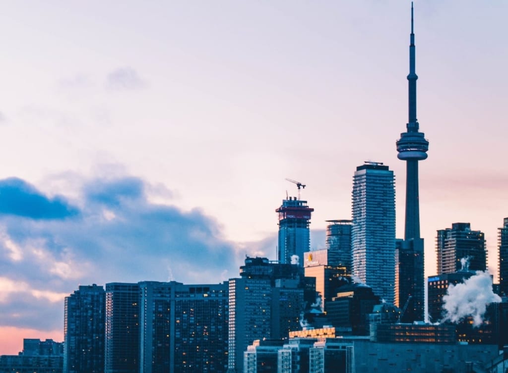 Toronto skyline from island beach at dusk.